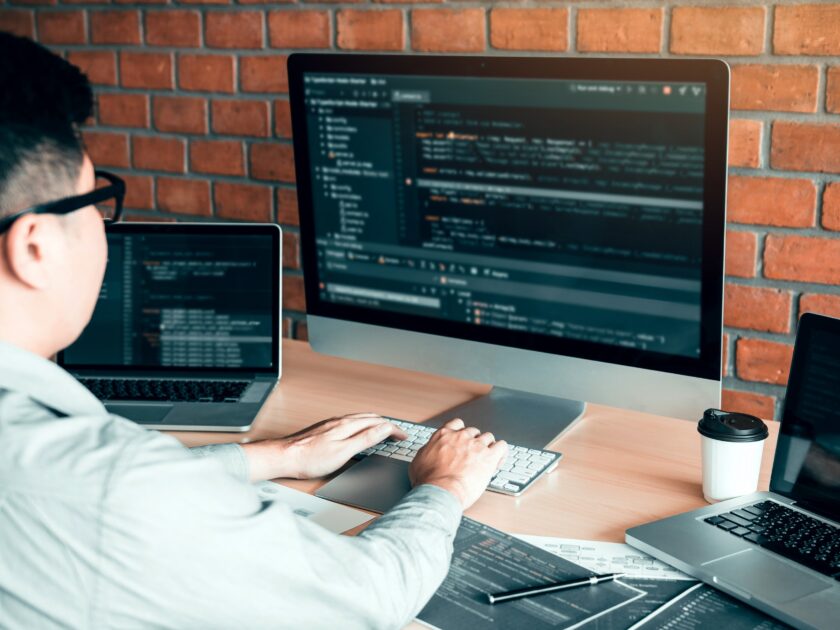 Asian man working code program developer computer web development working design software on desk in office.